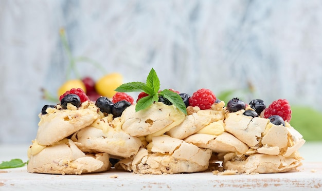 Um bolo assado feito de proteína de frango batido e creme decorado com frutas frescas Sobremesa Pavlova