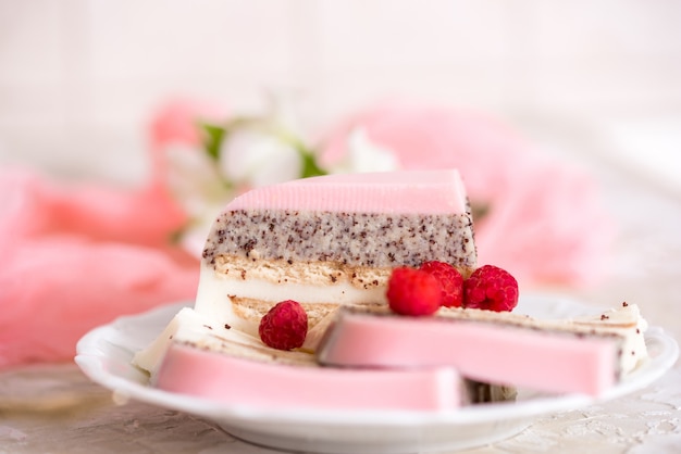 Um bolo doce rosa copo rosa com bule de chá e copo em cima da mesa