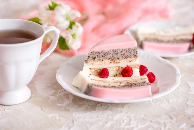 Um bolo doce rosa copo rosa com bule de chá e copo em cima da mesa