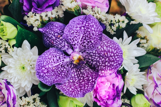 Um bouquet de flores em tons roxos com uma orquídea tigre no centro. Fechar vista