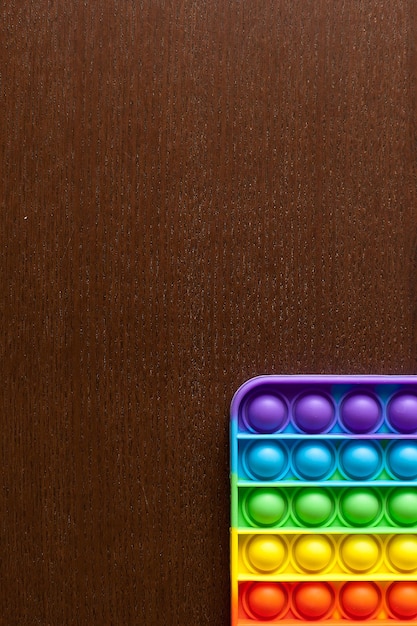 Um brinquedo com um fundo de textura de silicone. cores dos tons do arco-íris. fidget push pop é um brinquedo sensorial anti-stress.