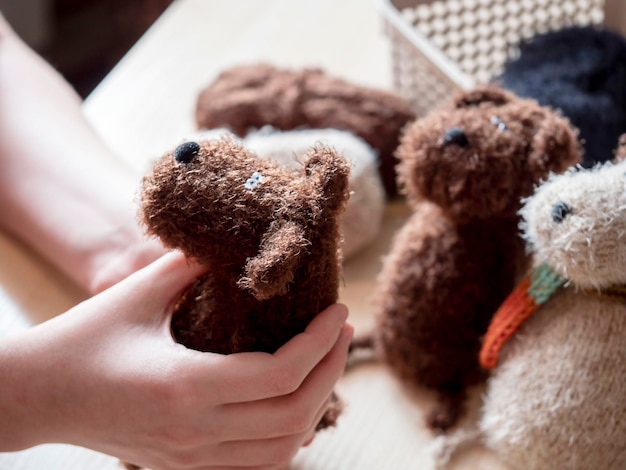 Um brinquedo de malha nas mãos de uma jovem Conceito de tricô feito à mão uma atividade para a alma e a saúde mental