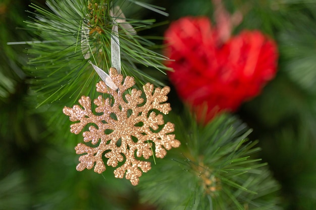 Um brinquedo de natal um brinquedo em forma de floco de neve em um galho de uma árvore de natal