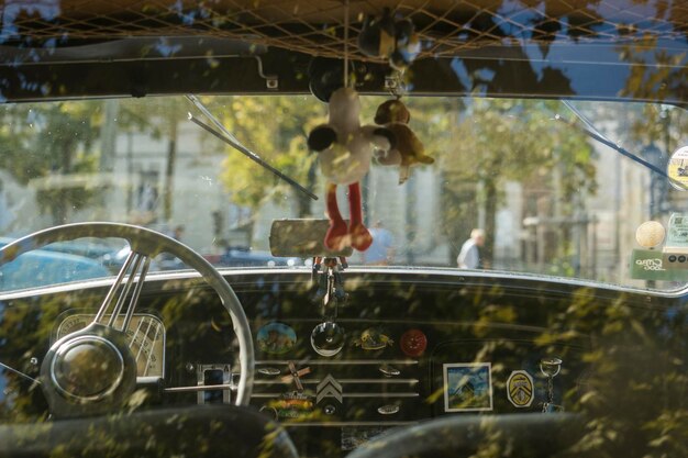 Foto um brinquedo pendurado num carro antigo.