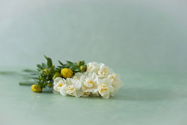 Um buquê de flores brancas com folhas amarelas e fundo verde