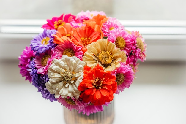 Um buquê de flores de outono de zínia e áster em fundo de cimento cinza