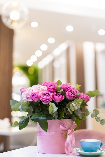 Um buquê de flores na mesa e uma xícara de café