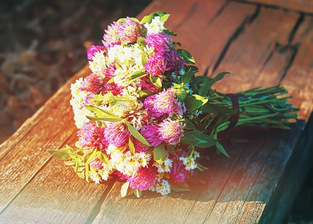 Um buquê de flores silvestres está sobre uma mesa de madeira