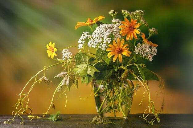 Um buquê de flores silvestres recém-colhidas e ervas medicinais ao ar livre na mesa