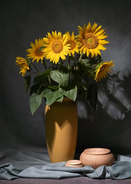 Um buquê de girassóis em um vaso amarelo no chão