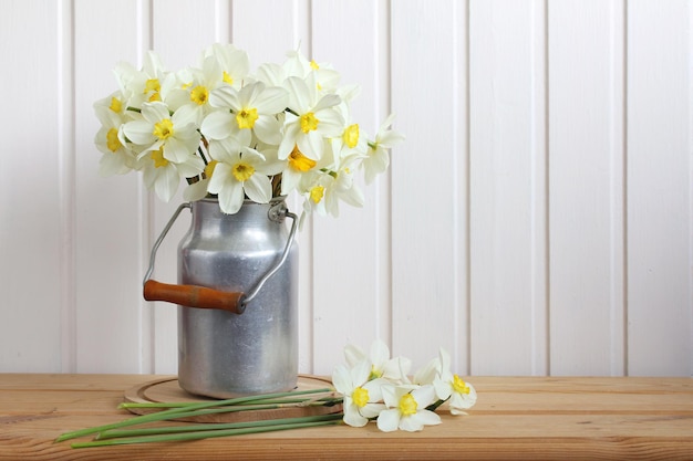 Um buquê de narcisos brancos em uma lata de alumínio em uma mesa dentro de casa Flores da primavera