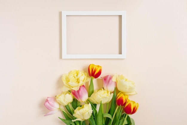 Um buquê de primavera brilhante de tulipas e um quadro de texto em um fundo bege com espaço de cópia Cartão de felicitações planas