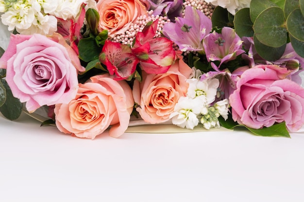 Um buquê de rosas cor de rosa e laranja coloridas em uma mesa branca Copie o espaço para texto ou design Flores