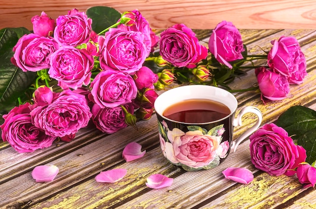 Foto um buquê de rosas de peônia rosa uma chávena de chá decorada com rosas natureza morta romântica