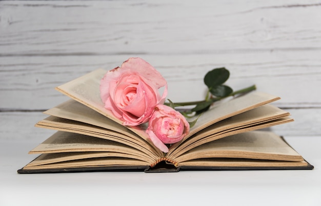 Um buquê de rosas e livros em madeira rústica