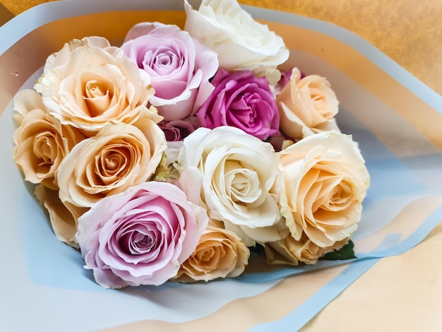 Foto um buquê de rosas está em uma bolsa azul e branca.