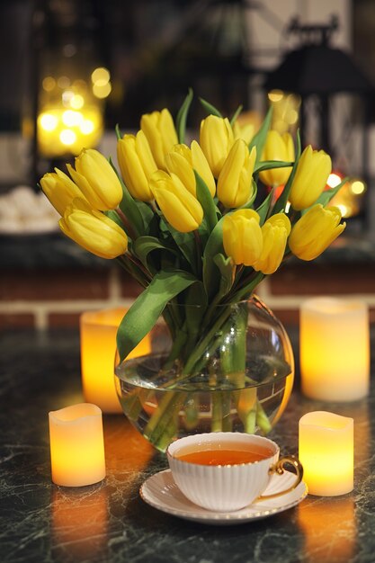 Um buquê de tulipas amarelas em um vaso no interior de uma sala retrô. Interior retrô com buquê de tulipas.