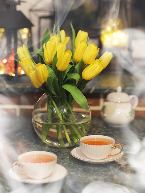 Um buquê de tulipas amarelas em um vaso no interior de uma sala retrô. Interior retrô com buquê de tulipas.