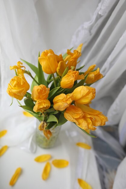 Um buquê de tulipas amarelas em um vaso no parapeito da janela. Um presente para o dia da mulher de flores de tulipa amarela. Lindas flores amarelas em um vaso perto da janela.