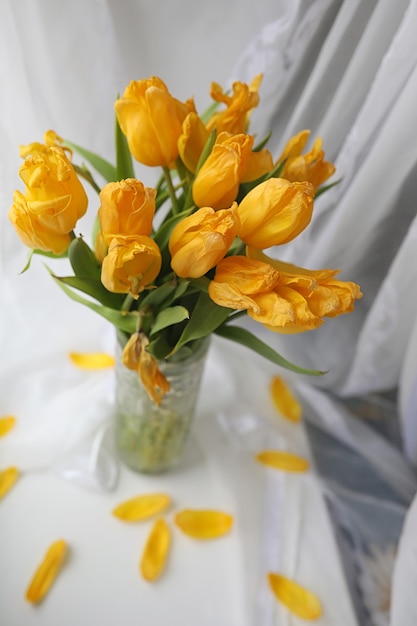 Um buquê de tulipas amarelas em um vaso no parapeito da janela. Um presente para o dia da mulher de flores de tulipa amarela. Lindas flores amarelas em um vaso perto da janela.
