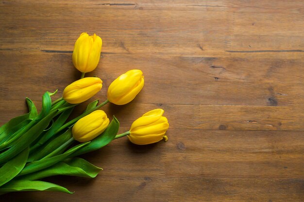 Foto um buquê de tulipas amarelas está em um chão de madeira dia das mulheres dia das mães 8 de março primavera