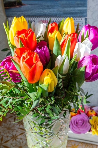 Um buquê de tulipas coloridas em um vaso de cristal Padrão e textura de flores naturais