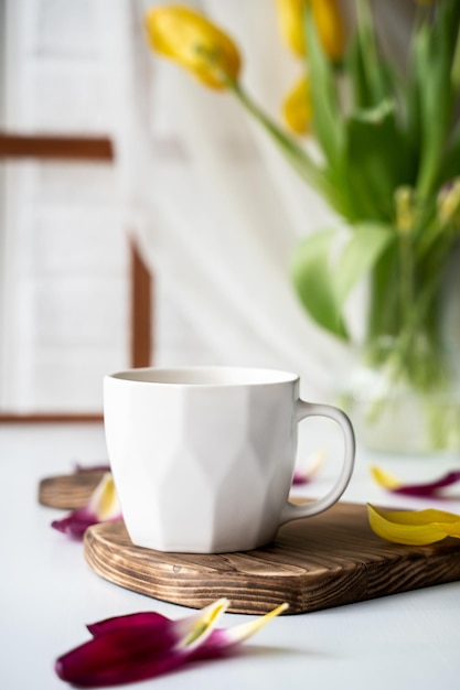 um buquê de tulipas desbotadas e os restos de café na mesa no final