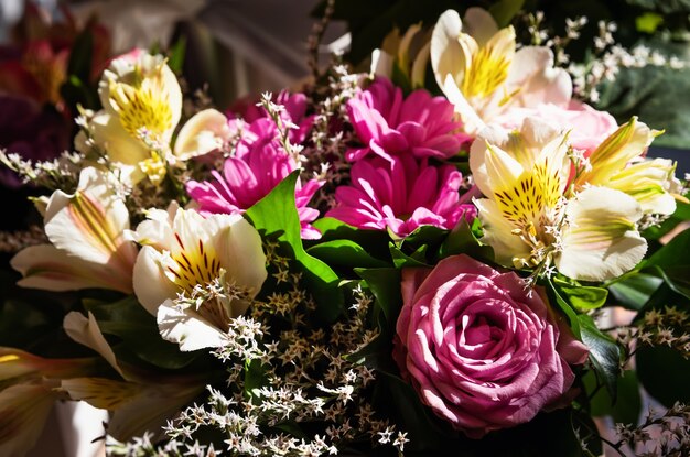 Um buquê festivo de rosas e outras flores de verão na luz do sol. Fundo de flor