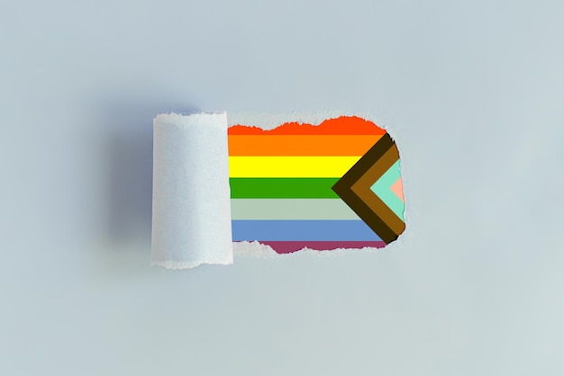 Um buraco estourado no papel com uma bandeira colorida lgbt