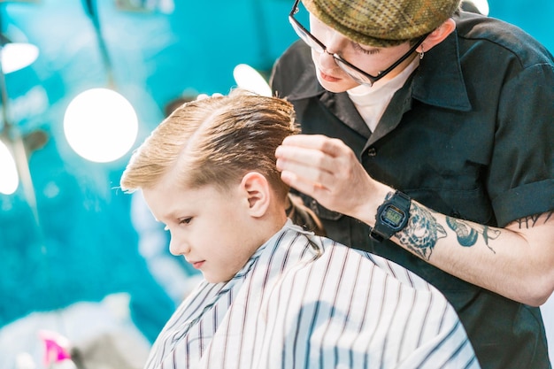 Um cabeleireiro na barbearia fazendo um penteado para um menino