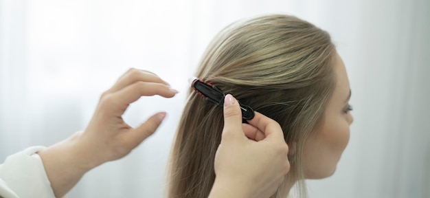 Foto um cabeleireiro profissional coloca uma alfinete no cabelo da mulher no salão.