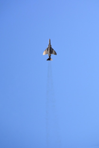 Foto um caça militar está voando no céu azul