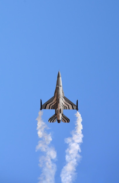 Um caça militar está voando no céu azul