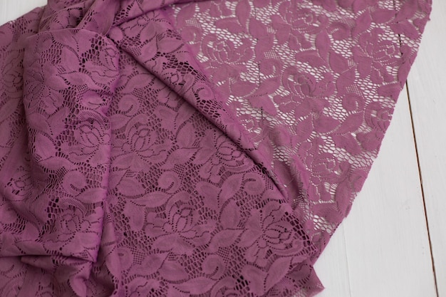 Um cachecol de renda roxo com um padrão floral na parte inferior.