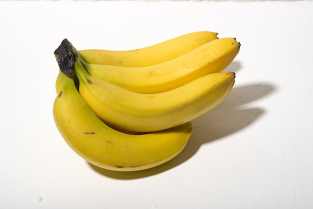 Um cacho de bananas como está em um fundo branco Luz dura
