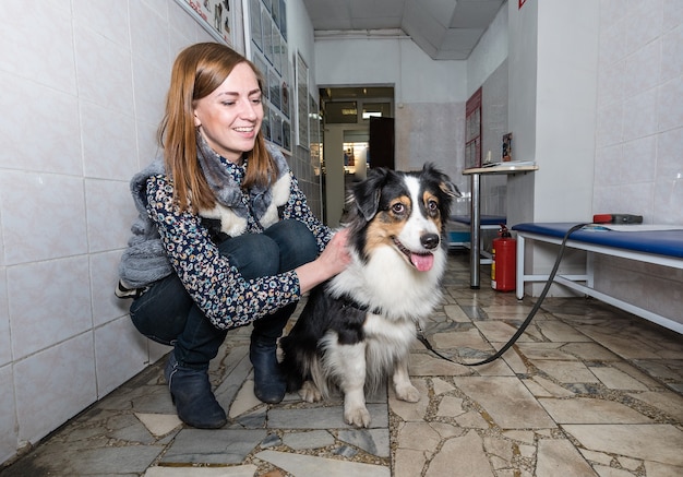 Um cachorro com o dono aguardando entrada no veterinário