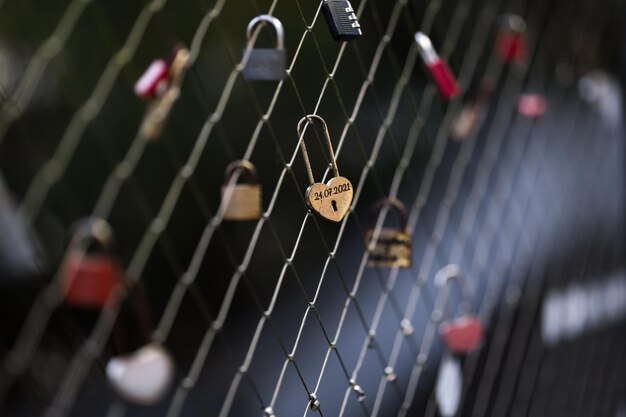 Um cadeado de coração pendurado na cerca de uma ponte como um sinal de amor e romance