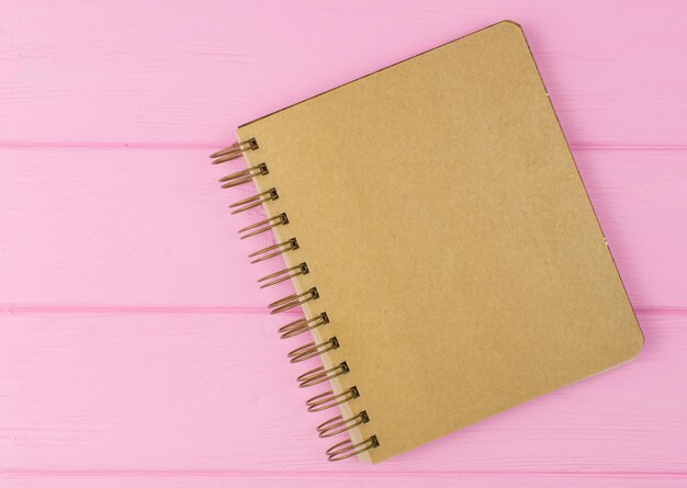 Um caderno de desenho em um fundo rosa de madeira