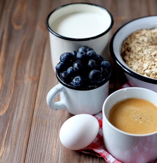 Um café da manhã saudável Mingau de aveia, leite de ovo cozido, bagas frescas e café