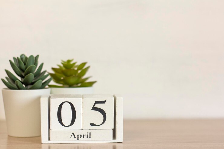 Um calendário de madeira com a data 5 de abril na área de trabalho.