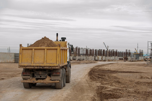 Um caminhão basculante laranja em uma área de construção