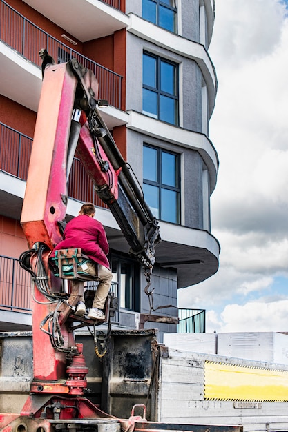 Foto um caminhão de máquina com um guindaste carregador descarrega blocos para a construção de uma casa.