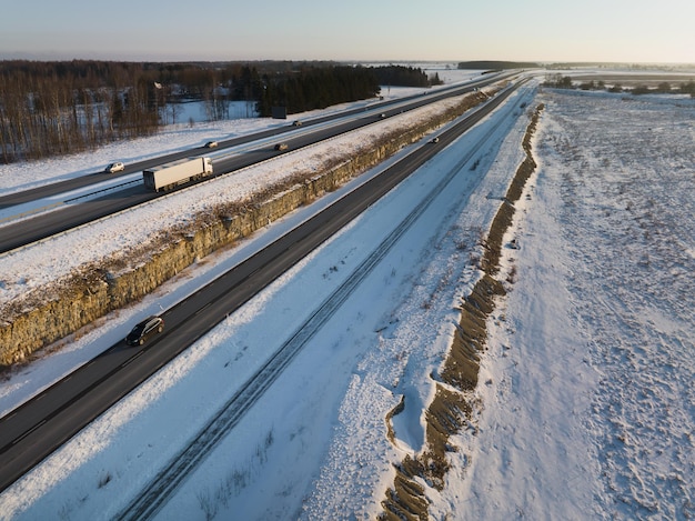 Foto um caminhão e outros veículos comem ao longo da rodovia em uma foto de manhã de inverno de um drone