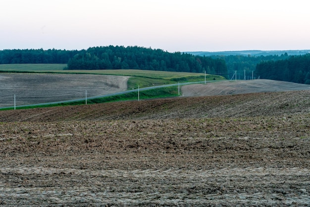Um campo arado contra o céu A temporada de plantio de culturas em um campo de trigo Preparando o campo para o plantio de centeio e cevada em áreas rurais