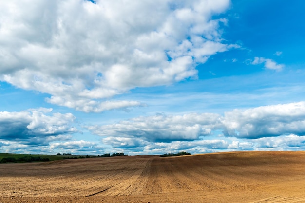 Um campo arado contra o céu A temporada de plantio de culturas em um campo de trigo Preparando o campo para o plantio de centeio e cevada em áreas rurais
