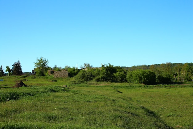 um campo com uma casa no topo dele