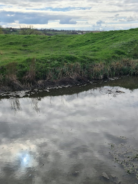 Um campo verde com um céu nublado ao fundo