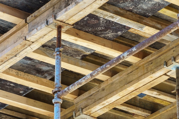 Um canteiro de obras ao ar livre Construção de um novo edifício Construção de blocos de vigas de concreto armado e pisos e telhados de madeira