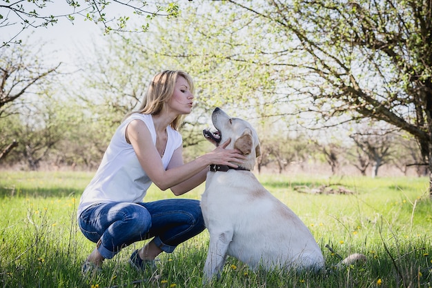 Um cão labrador brinca com uma loira.