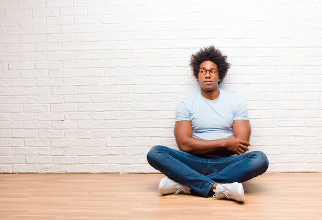 um cara afro-americano sentado e duvidando ou pensando